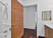 Thumbnail 25 of 49 - A wooden door is open to a white bathroom.