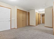 Thumbnail 34 of 66 - A hallway with white doors and carpeted floors.