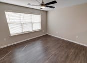 Thumbnail 3 of 26 - a bedroom with hardwood floors and a ceiling fan