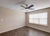 Thumbnail 9 of 26 - a bedroom with a large window and a ceiling fan