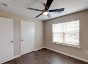 Thumbnail 16 of 26 - a bedroom with hardwood floors and a ceiling fan