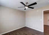 Thumbnail 25 of 26 - a bedroom with a ceiling fan and hardwood floors