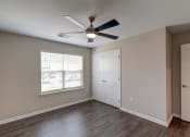 Thumbnail 21 of 26 - a bedroom with hardwood floors and a ceiling fan