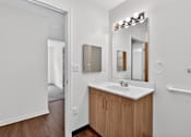 Thumbnail 32 of 49 - A bathroom with a sink, mirror, and a white door.