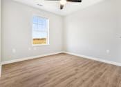 Thumbnail 20 of 26 - an empty living room with wood floors and a window
