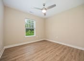 Thumbnail 14 of 48 - Empty room with a ceiling fan and a window.