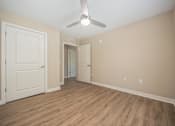 Thumbnail 4 of 48 - A room with a ceiling fan and wooden flooring.