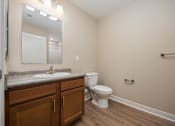Thumbnail 19 of 48 - A bathroom with a toilet, sink, and mirror.