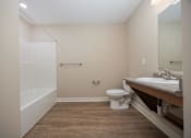 Thumbnail 38 of 48 - A bathroom with a toilet, sink, and mirror.