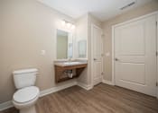 Thumbnail 41 of 48 - A bathroom with a toilet, sink, and mirror.