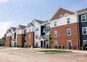 Thumbnail 35 of 48 - A row of townhouses with a parking lot in front.
