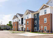 Thumbnail 33 of 48 - A row of townhouses with a parking lot in front.
