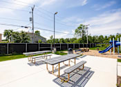 Thumbnail 6 of 48 - A picnic table is in the middle of a playground.