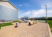 Thumbnail 23 of 48 - A playground with a slide and a play area with a wooden structure.