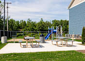 Thumbnail 13 of 48 - A playground with a slide, picnic table, and trash can.