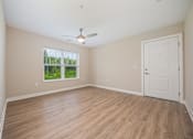 Thumbnail 3 of 48 - A room with a white door and a ceiling fan.