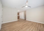 Thumbnail 12 of 48 - A room with a ceiling fan and wooden flooring.