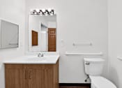 Thumbnail 24 of 49 - A white toilet sits next to a sink in a bathroom.
