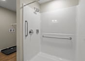 Thumbnail 31 of 39 - a white bathroom with a shower and a towel rack
