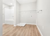 Thumbnail 22 of 26 - a white bathroom with a shower and a wooden floor