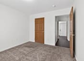 Thumbnail 44 of 49 - A room with a brown door and carpeted floor.