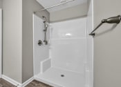 Thumbnail 6 of 18 - A white shower stall with a glass door and a shower head.