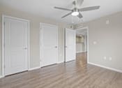 Thumbnail 29 of 39 - an empty living room with white doors and a ceiling fan