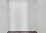 Thumbnail 48 of 49 - A white room with a brown carpet and two white shelves on the wall.