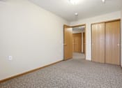 Thumbnail 39 of 66 - A hallway with two doors and a carpeted floor.