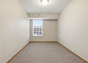 Thumbnail 40 of 66 - A room with a window and carpeted floor.