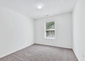 Thumbnail 43 of 49 - A room with a window and carpeted floor.