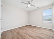 Thumbnail 29 of 35 - an empty living room with a ceiling fan and a window
