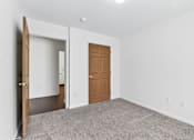 Thumbnail 42 of 49 - A room with a brown door and a white wall.