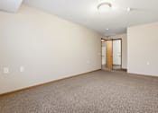 Thumbnail 41 of 66 - A room with a carpeted floor and a wooden door.