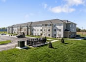 Thumbnail 4 of 26 - an exterior view of an apartment building with a parking lot