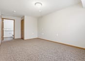Thumbnail 43 of 66 - A room with a carpeted floor and a doorway leading to another room.