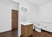 Thumbnail 36 of 49 - A white bathroom with a toilet, sink, and mirror.