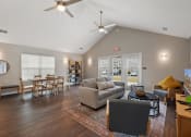 Thumbnail 32 of 37 - a living room with a couch and a table and a ceiling fan