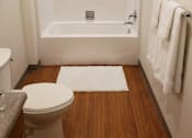 Thumbnail 30 of 30 - A white toilet sits next to a white bathtub in a small bathroom.