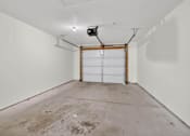 Thumbnail 47 of 49 - A garage with a white door and a white wall.