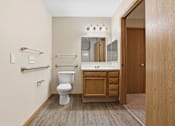 Thumbnail 52 of 66 - A white toilet sits in a bathroom with a wooden vanity and medicine cabinet.