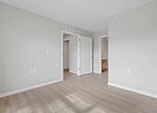 Thumbnail 12 of 76 - a spacious living room with white walls and wood floors