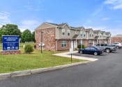 Thumbnail 4 of 37 - an apartment complex with cars parked in a parking lot