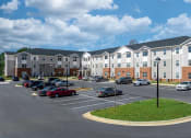 Thumbnail 8 of 22 - a parking lot with cars in front of an apartment building