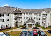 Thumbnail 57 of 66 - A large white building with a parking lot in front.