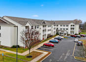 Thumbnail 58 of 66 - A parking lot in front of a white building with a blue sky in the background.