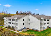 Thumbnail 65 of 66 - A large white building with a green lawn in front.