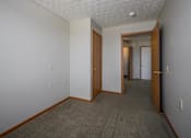 Thumbnail 10 of 33 - A hallway with carpeted flooring and white walls.
