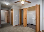 Thumbnail 7 of 33 - A room with a ceiling fan and a doorway leading to another room.