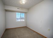 Thumbnail 22 of 33 - A room with a window and a carpeted floor.